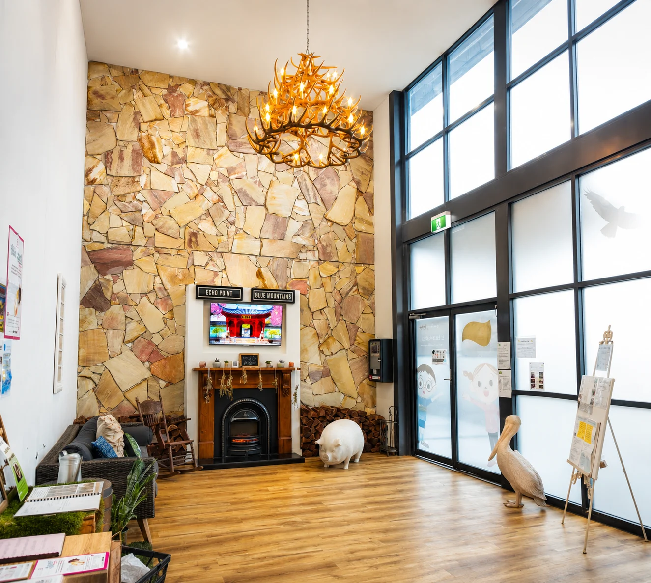 Antler chandelier feature over a double-height stone wall